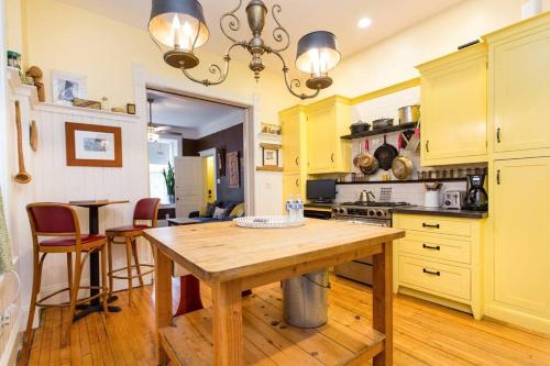 uma cozinha com armários amarelos e uma mesa de madeira em iKlektik House // BlueJay em Chicago