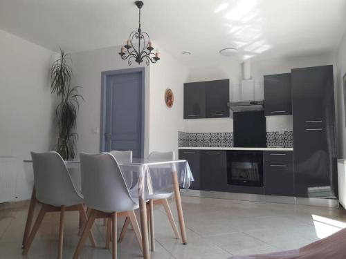 a dining room with a glass table and chairs at Maison dans une propriété avec une cour in Corneilhan
