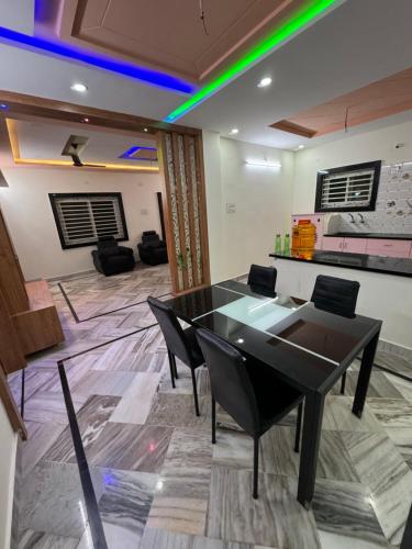a dining room with a black table and chairs at Karthikeya villa’s in Narasaraopet