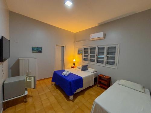 a bedroom with a bed with a blue blanket at Pousada de Bonito in Bonito