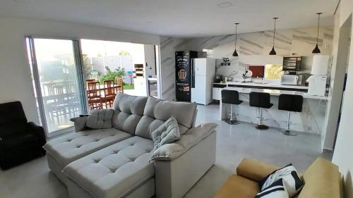 een woonkamer met een bank en een keuken bij Casa Barramar Temporada 1 in Barra de São Miguel