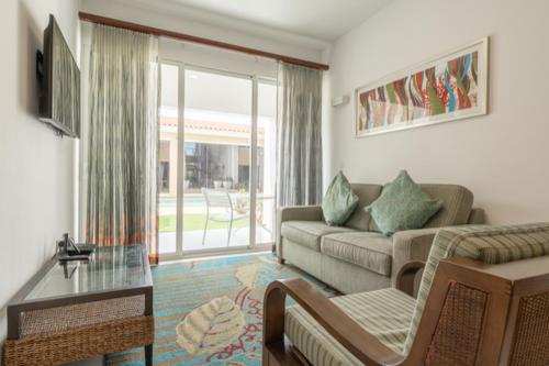 een woonkamer met een bank en een tafel bij Aruba's Life Vacation Residences - By Heritage Property Management in Noord