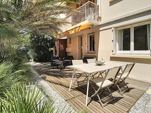d'une terrasse avec une table et des chaises blanches. dans l'établissement Berlioz Garden - Jardin,Free Parking,AC,Wifi, à Antibes