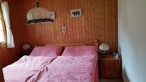 una camera con un letto e un piumone rosso e bianco di Chalet Sonnenblick a Fiesch