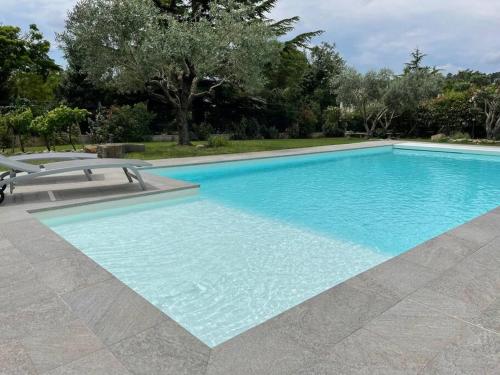 a large swimming pool with blue water at Chez Francis & Valérie in Villegailhenc