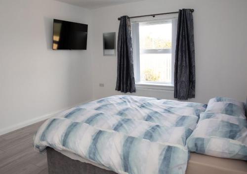 1 dormitorio con cama y ventana en Riverview Cottages, en Cookstown