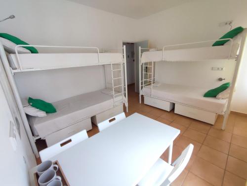a room with two bunk beds and a table at Racing Mackerel Hostel in Lagos