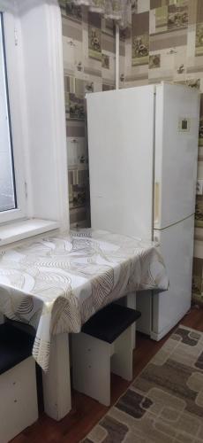 biała ławka w pokoju z lodówką w obiekcie Квартира w mieście Taraz