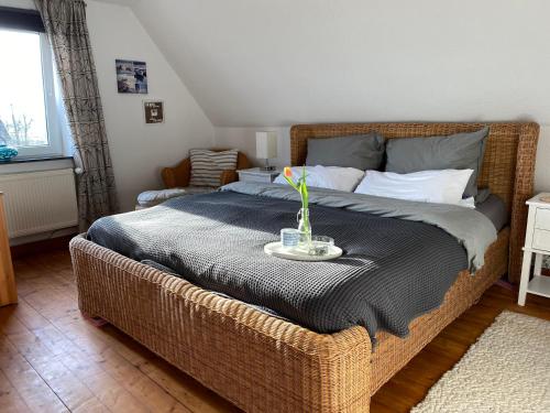 een slaapkamer met een rieten bed en een vaas erop bij Ferienhaus Norddeichkieker in Norddeich