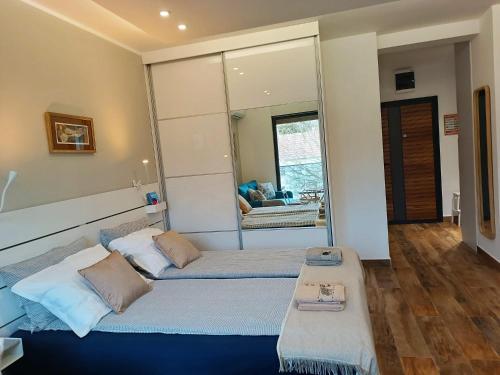 a bedroom with two beds and a large mirror at Hedonica 11 Ema in Vrdnik