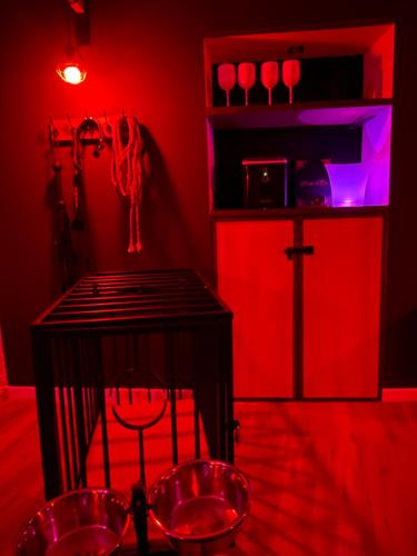 a red room with a cage and red lights at L’Evasion la Love Room de Fayence in Fayence