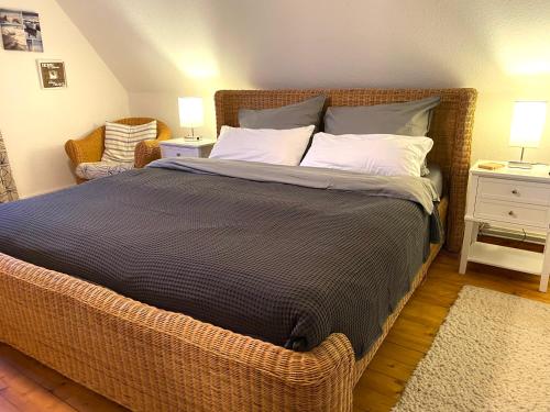 a bedroom with a large bed with a wicker frame at Ferienhaus Norddeichkieker - Büsum in Norddeich