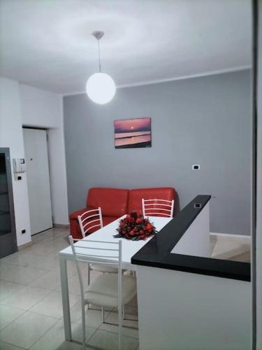 a living room with a table and a red couch at Lety's home in Sulmona