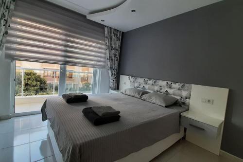 1 dormitorio con cama grande y ventana grande en Happy Suites 9, en Alanya