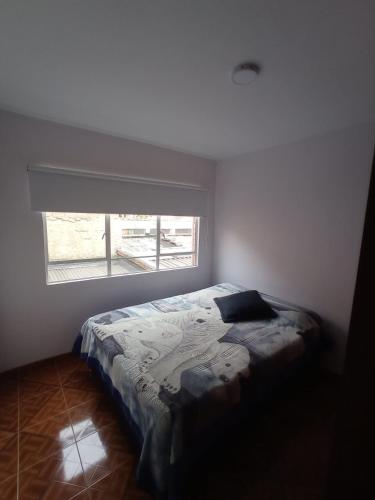 een slaapkamer met een bed voor een raam bij La Posada De Ani in Bogota