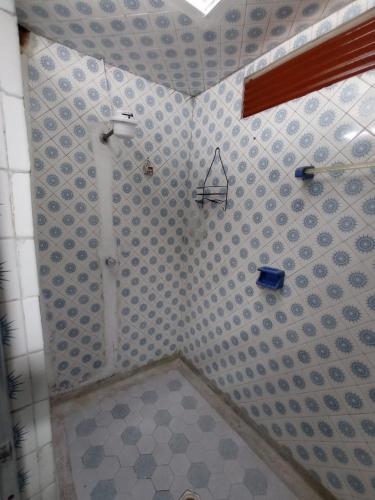 een badkamer met een douche en een betegelde muur bij La Posada De Ani in Bogota