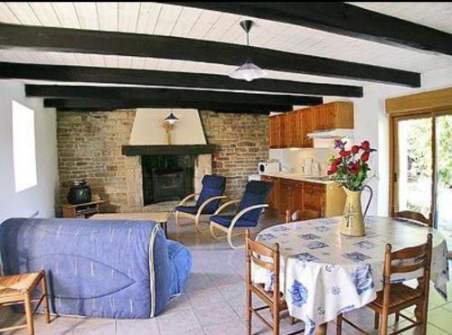 un salon avec un canapé bleu et une table dans l'établissement Charmante petite maison bretonne, à Rosporden