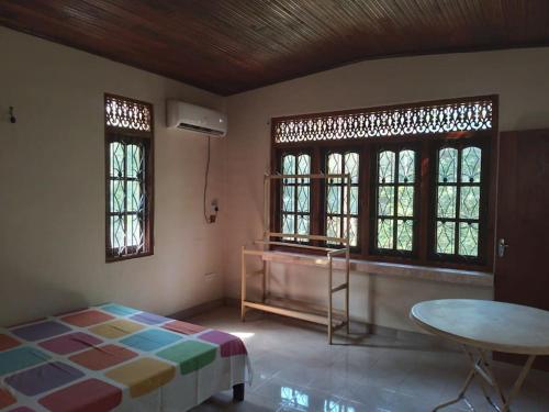 um quarto com uma cama, uma mesa e janelas em Holiday Home in Mirigama em Mirigama