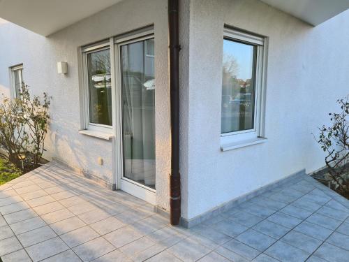 a house with two windows and a patio at WellandHome- Deluxe Apartment Schechingen in Schechingen