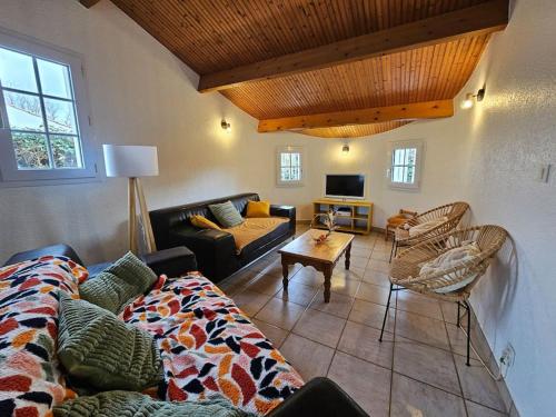 ein Wohnzimmer mit einem Sofa und einem Tisch in der Unterkunft Maison 4 ch*L'Aiguillon s/ Mer in LʼAiguillon-sur-Mer