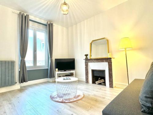 a living room with a fireplace and a mirror at L Étoilé Appartement tout confort à Epinal Gare Classé 3 étoiles in Épinal