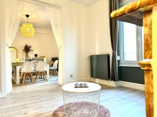 a living room with a table and some chairs at L Étoilé Appartement tout confort à Epinal Gare Classé 3 étoiles in Épinal