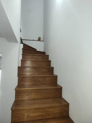a wooden staircase in a house with a person walking up it at Duplex Victoria in Luján
