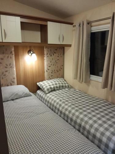 two beds in a small room with at Sunnymeade Holiday Park i3 St David in Ingoldmells