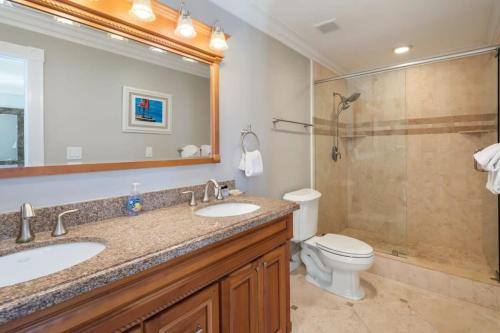 a bathroom with two sinks and a toilet and a shower at Atlantic Oasis - Private Pool Parking & Downtown in Key West