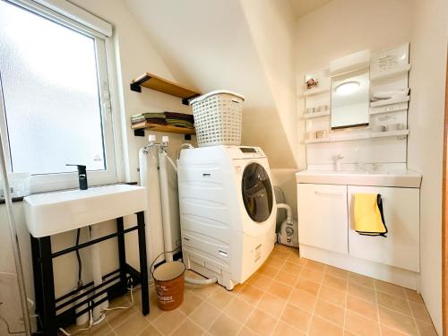 a bathroom with a washing machine and a sink at Kaito/9min walk to Noboribetsu st. in Tomiura