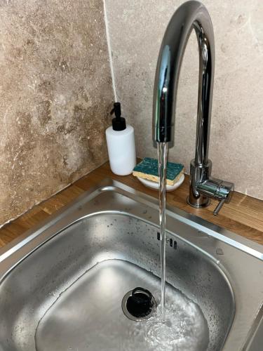 d'un évier de cuisine avec de l'eau provenant d'un robinet. dans l'établissement Appartement douillet en ville, à Ajaccio