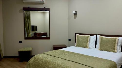 a bedroom with a large bed and a mirror at Rritja e Koranit in Pogradec