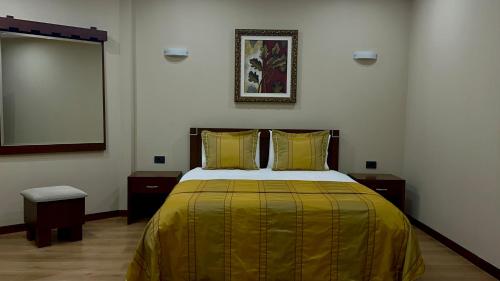 a bedroom with a large bed with yellow sheets at Rritja e Koranit in Pogradec