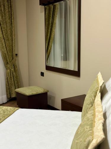 a bedroom with a bed and a mirror at Rritja e Koranit in Pogradec