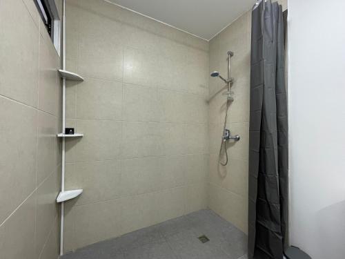 a bathroom with a shower with a black shower curtain at Appartement avec vue sur le port de Papeete in Faaa