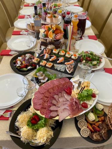 una mesa larga con platos de comida. en "Аромат Греції" en Berehomet