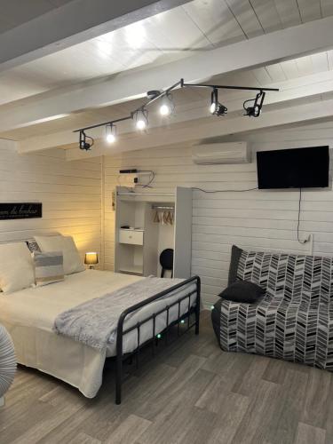 een slaapkamer met een bed en een flatscreen-tv bij LE MAS RESCATOR in Vence