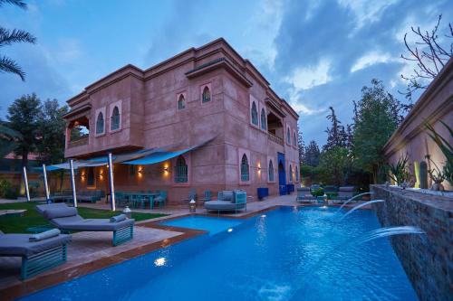 a house with a swimming pool next to a building at Villa Taj Sofia & Spa in Marrakech