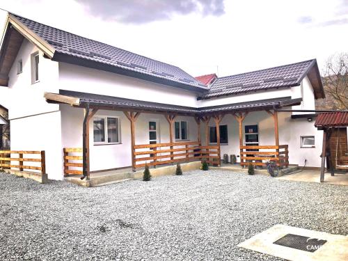 a white house with a fence and a driveway at Cabana La Batranu in Borşa