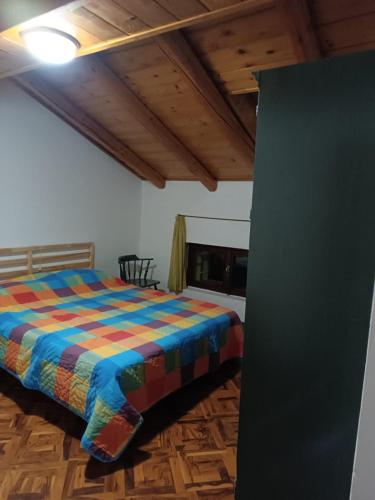 ein Schlafzimmer mit einem Bett mit einer bunten Decke in der Unterkunft Vacanza Rurale in Rabbi