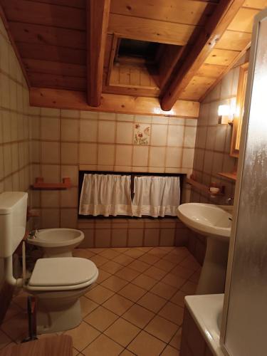 a bathroom with two toilets and a sink at Vacanza Rurale in Rabbi