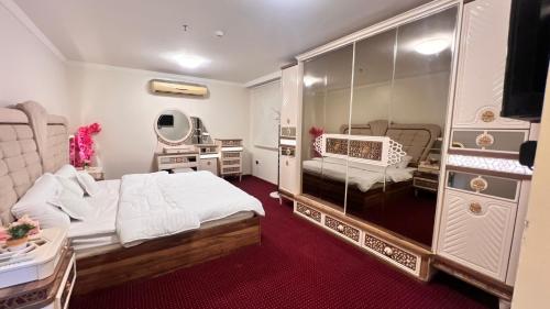 a bedroom with a bed and a mirror at شقة درة الإجابة السياحية in Mecca