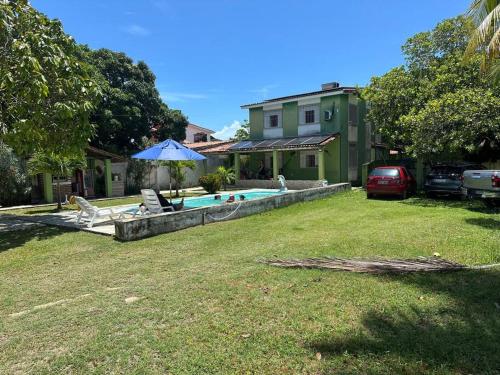 a backyard with a swimming pool and a house at Casa Grande com Piscina no Pilar in Itamaracá