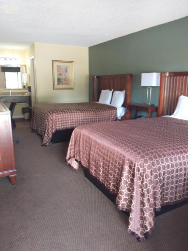Habitación de hotel con 2 camas con sábanas rojas en Apalachicola Bay Inn, en Apalachicola