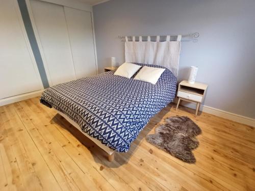 a bedroom with a bed with a blue comforter at Le Belvédère en baie, vue sur la baie in Saint-Valery-sur-Somme