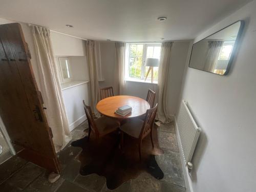 a dining room with a table and chairs and a window at Charming cottage near airport in Yatton