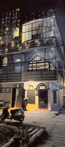 FaizābādにあるSaraswati Sadan Homestay Ayodhyaのスクーターが前に停まった建物