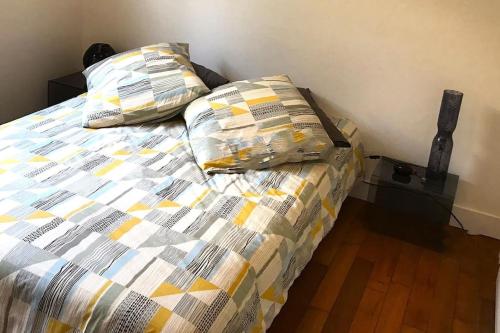 une chambre avec un lit avec deux oreillers dessus dans l'établissement Appartement au cœur de Cannes, à Cannes