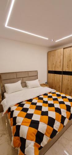 um quarto com uma cama com um cobertor xadrez em New amazing flat front of citystars mall no Cairo