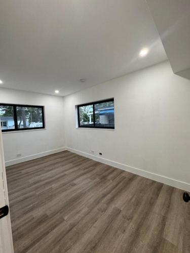 een lege kamer met witte muren en twee ramen bij William Home in Miami